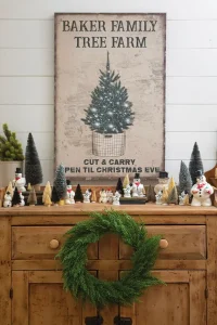 vintage style tree farm sign and vintage Frosty the snowman figurines surrounded by bottlebrush trees