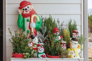 snowmen figurines surrounded by potted trees and shrubs on porch of modern collected farmhouse