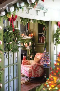 corner view of hallway and living room decked in wreaths garlands and vintage ornaments