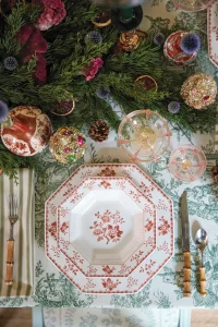 place settings with bamboo style cutlery and octagonal red and white china against green and white chinoiserie style tablecloth