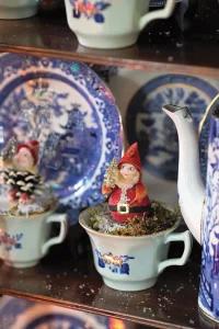 vintage pinecone elves sit atop vintage teacups
