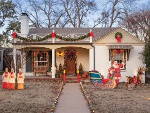 exterior view of home decorated for Christmas with handmade cutouts of Santa reindeer and sleigh based on vintage patterns