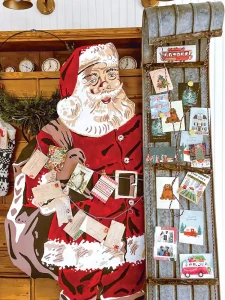 Christmas cards displayed using vintage sled and Santa cutout