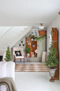 garland and white village scene under the stairs in neutral serene holiday home