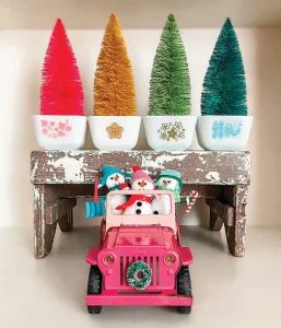 bright notes of nostalgia with vintage Pyrex bowls with coordinating colors of bottlebrush trees and toy pink Jeep with three snowmen in colorful hats and scarves