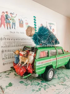 toy vintage station wagon with bottlebrush tree strapped to the top