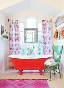 bathroom with floral curtain and red clawfoot tub