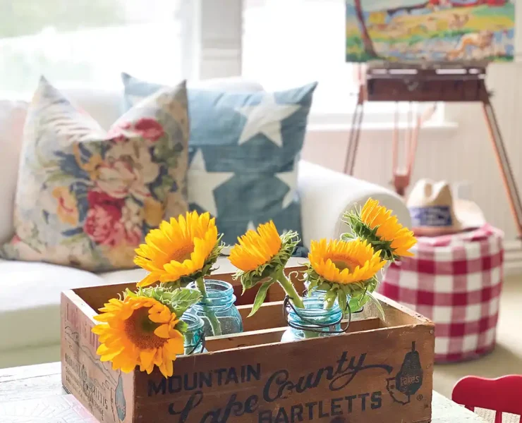 vintage wooden crate displays sunflowers on coffee table in collector's home
