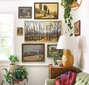 gallery wall of landscape and still life art in living room