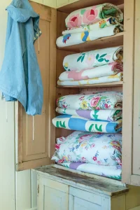 cabinet of quilts in cottage by the bay