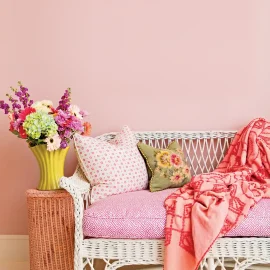 garden-inspired decor with white wicker bench with bright floral cushions