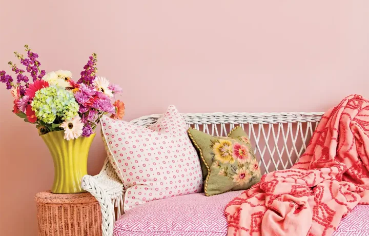 garden-inspired decor with white wicker bench with bright floral cushions