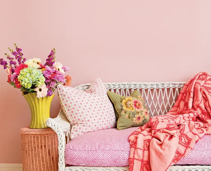 garden-inspired decor with white wicker bench with bright floral cushions